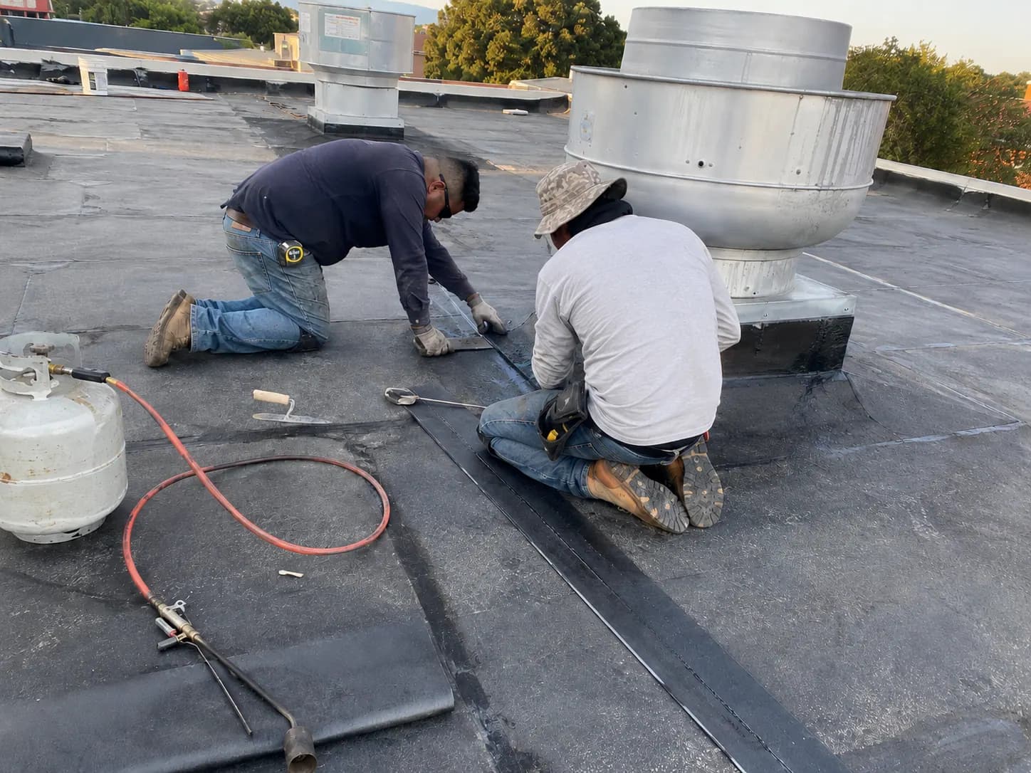 Commercial roofers completing modified bitumen detail work