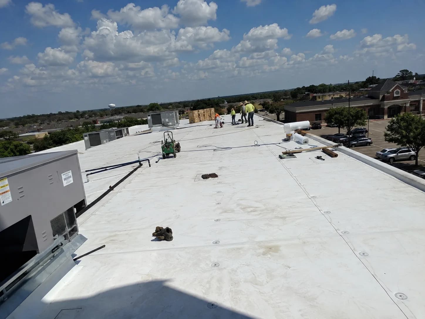 Hail King crew working across a white TPO roof on a Dallas commercial property