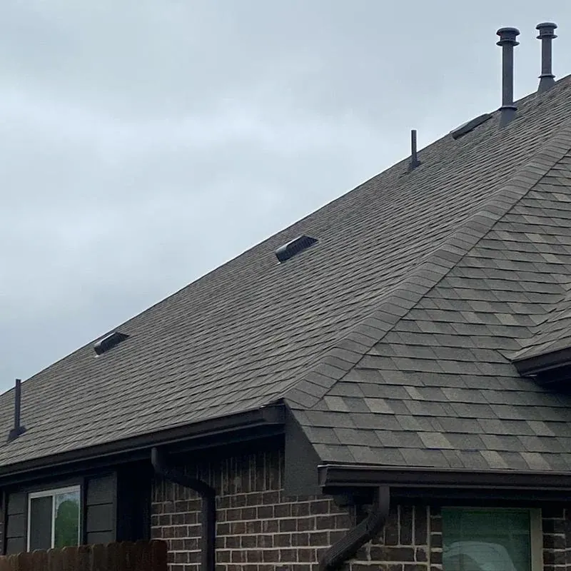 Black gutter and downspout installed on a Dallas-area brick home