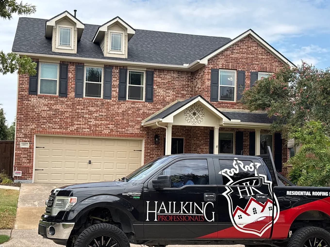 Hail King Professionals truck parked outside a two-story brick home