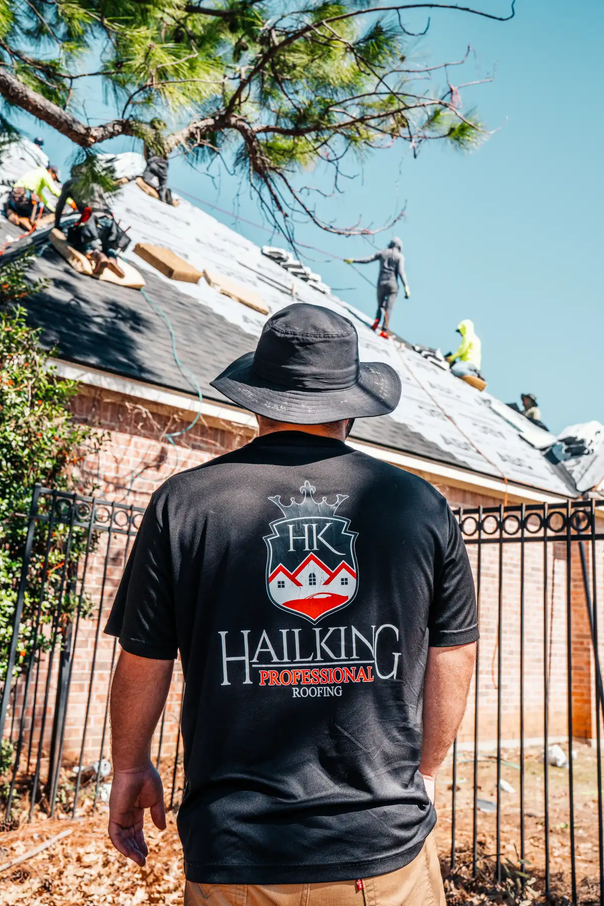 Hail King team member overseeing a residential roofing crew at work