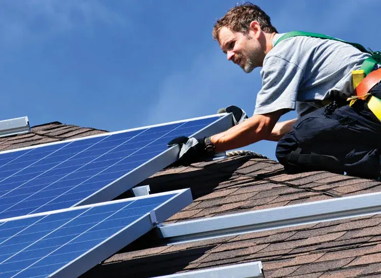 Solar installer securing a panel mounting system to a shingle roof