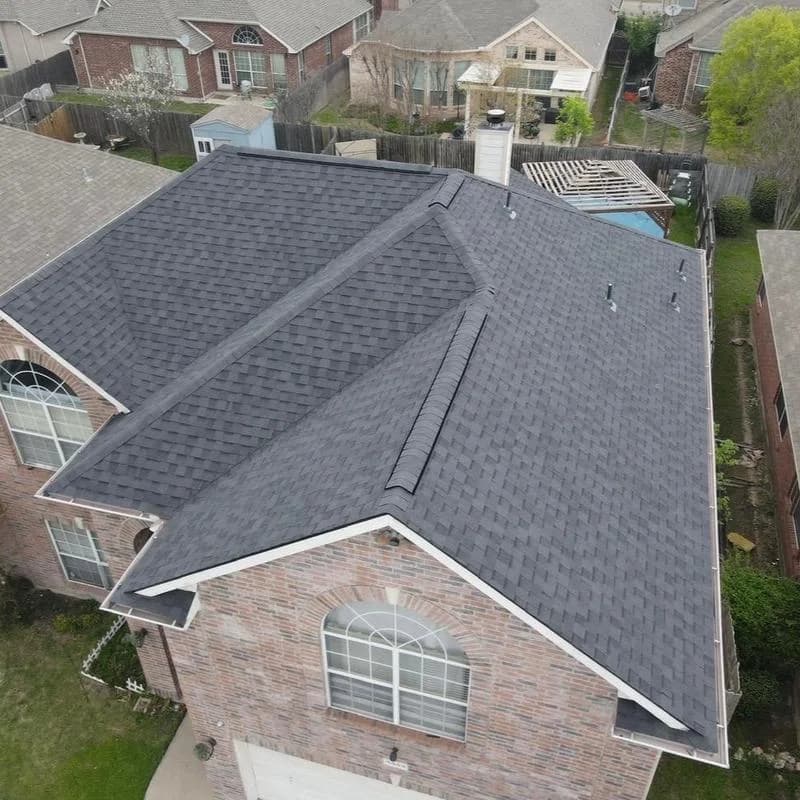 Aerial view of a completed shingle roof on a brick home
