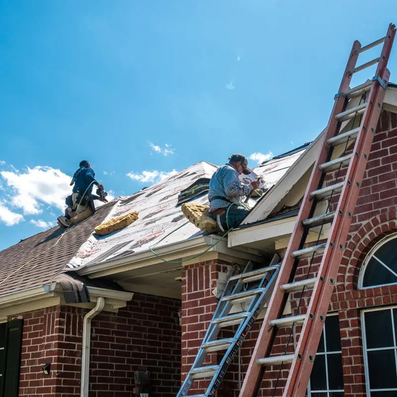 Crew replacing a roof on a North Texas brick home