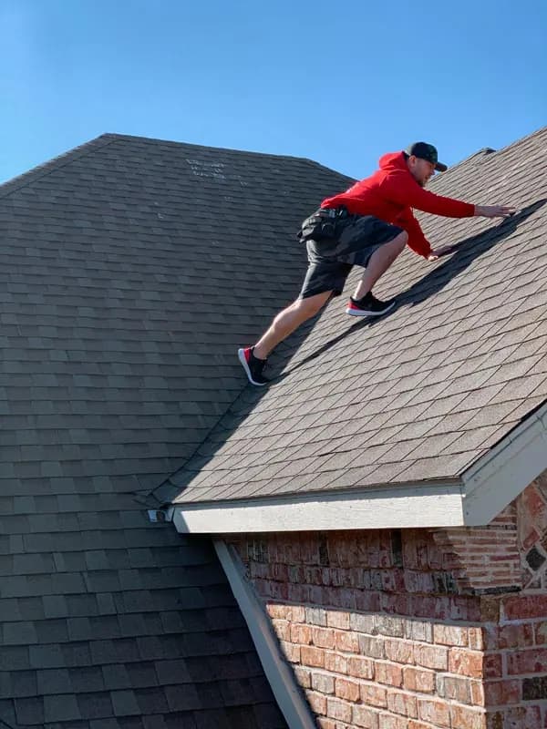 Installer aligning architectural shingles on a pitched roof