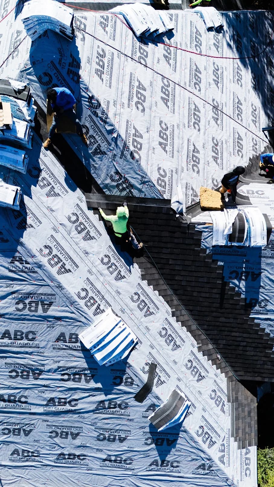 Overhead view of a McKinney crew installing shingles over roof underlayment