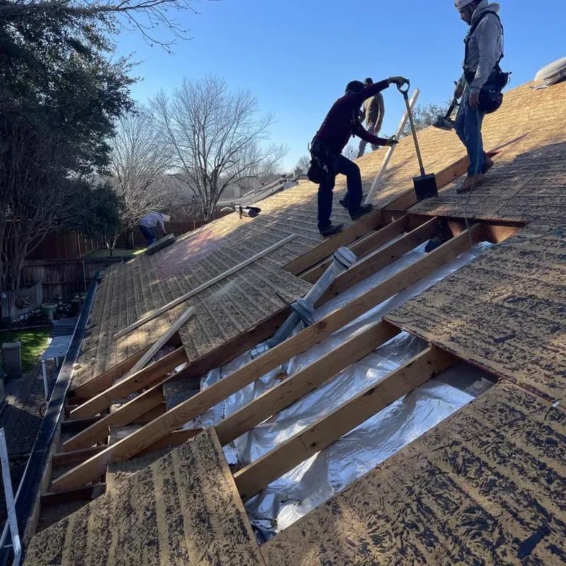 Crew removing roof decking to expose and prepare the structure below