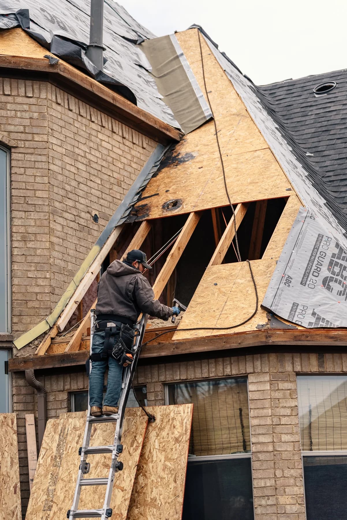 Roofer working beside an opening in the roof decking