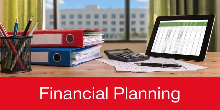 A desktop workspace featuring a tablet with financial data, binders, a calculator, and pens.