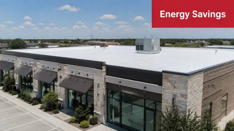 An aerial view of a commercial building with a newly installed white energy efficient roof coating.