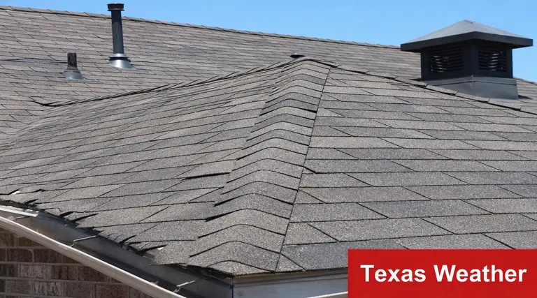 A close-up view of weathered asphalt roof shingles on a house showing signs of aging and wear.