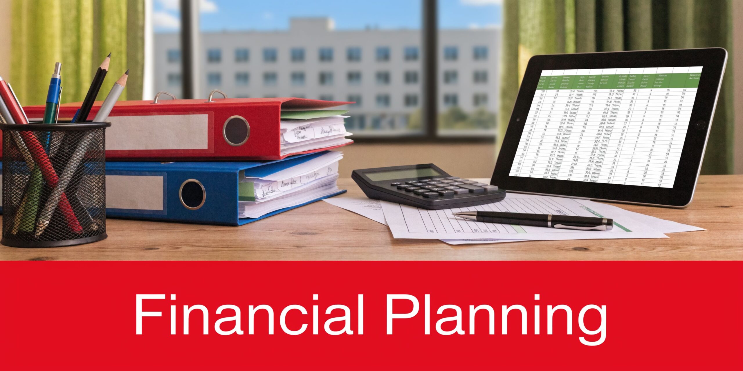 A desktop workspace featuring a tablet with financial data, binders, a calculator, and pens.