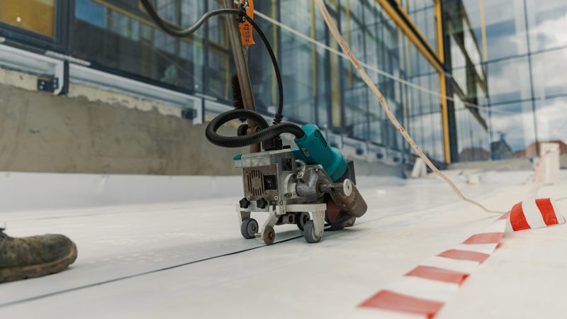 Worker welding pvc membrane by heater with welder machine